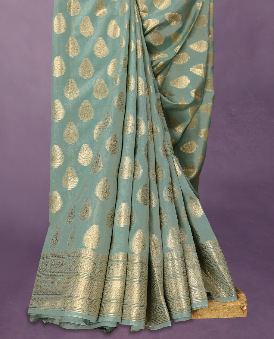 Light Aqua colour pure Banarasi Chanderi cotton, beautifully adorned with traditional antique zari Medium Butta designs across the body, completed with a hand-dyed colour, a traditional border, and a matching blouse.