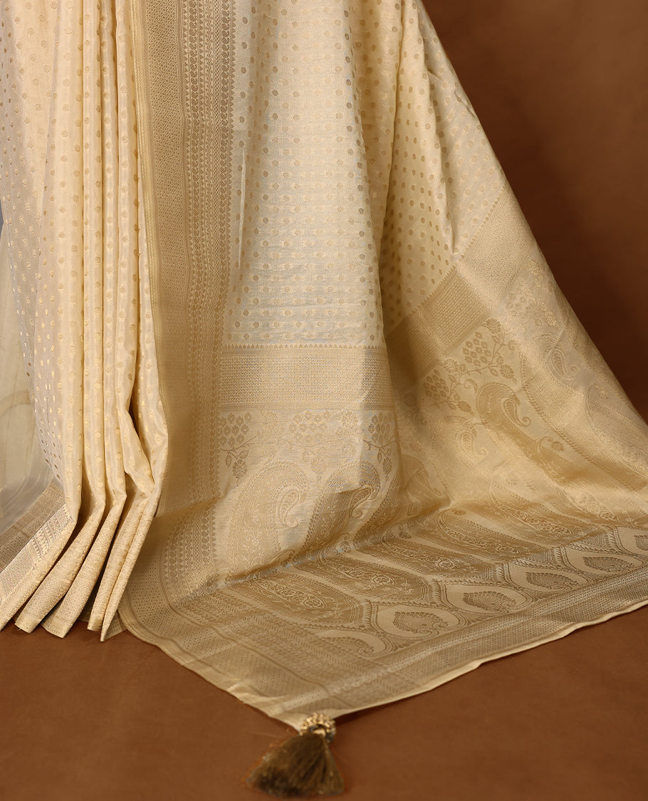 Off white colour georgette Kerala saree featuring intricate dotted woven patterns on the body, complemented by a subtly traditional border and pallu, paired with a matching blouse.