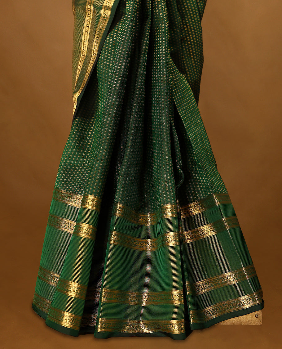 Bottle green Colour soft silk saree adorned with delicate golden zari flower motifs, featuring a stunning Neli Kamalam design border complemented by a plain blouse in a matching self-tone colour