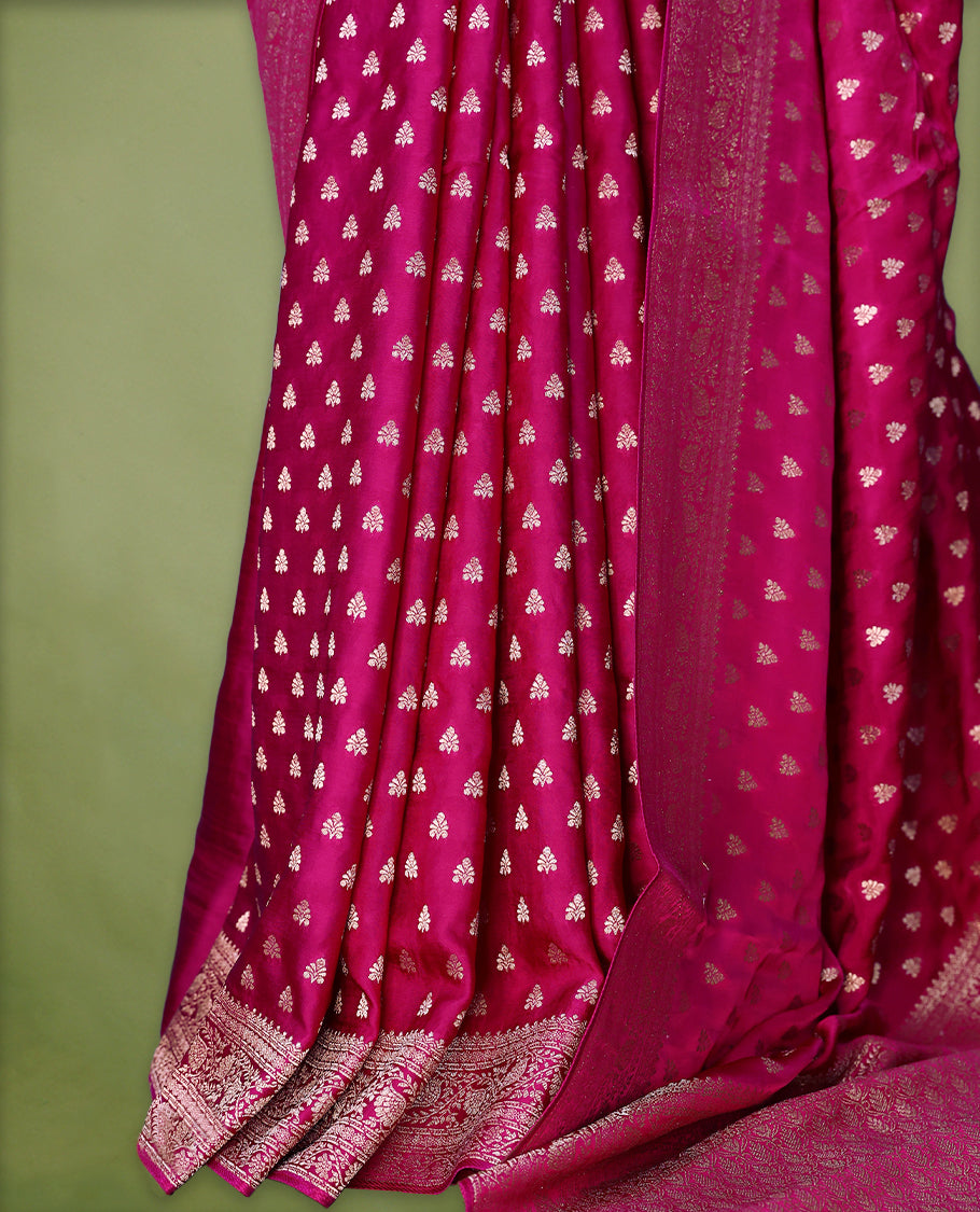 Rani Pink semi-Banaras satin crepe saree featuring traditional closely woven buttas on the body, complemented by an antique-style border and a matching self-coloured blouse.
