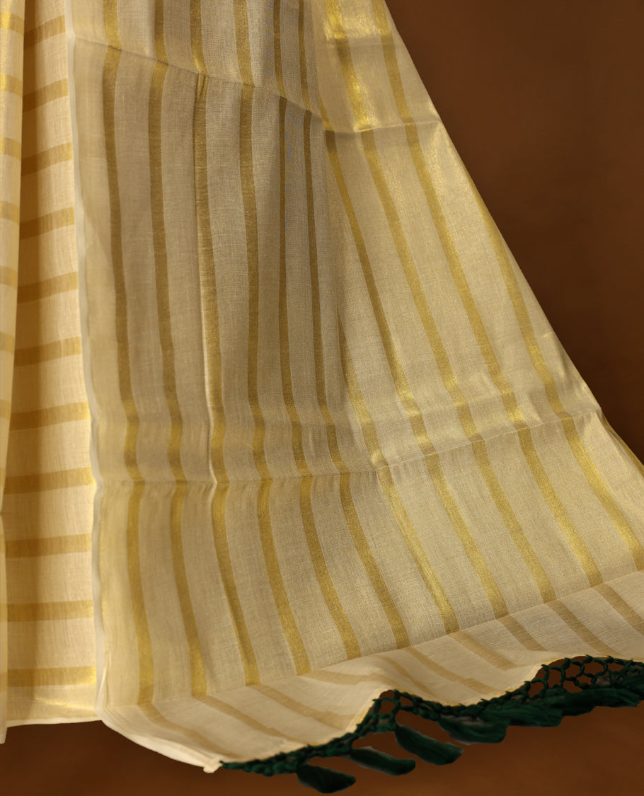 Light Gold colour Tissue Kerala saree featuring Gold zari Striped body, with Green colour tassels with a matching blouse perfect for festive occasions.