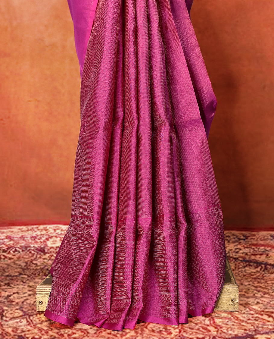 Deep magenta colour pure Mayuri silk saree featuring finely woven Golden zari motifs across the body, detailed with a subtle geometric self border with intricate texture, with matching blouse