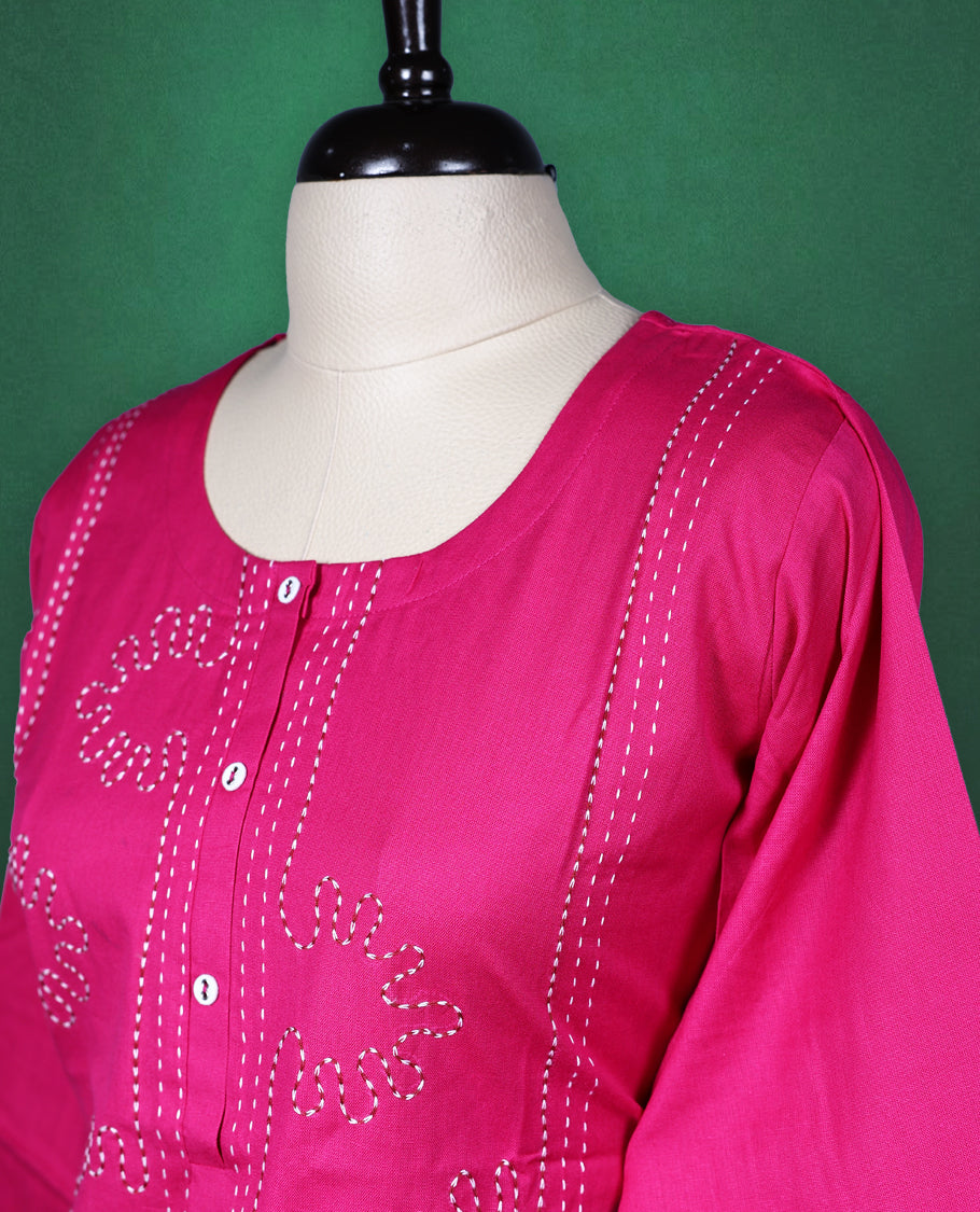 Magenta pink colour cotton kurti featuring delicate embroidery on the front, a round neckline with button detailing, and elbow length sleeves, vibrant and elegant pick for daily wear.