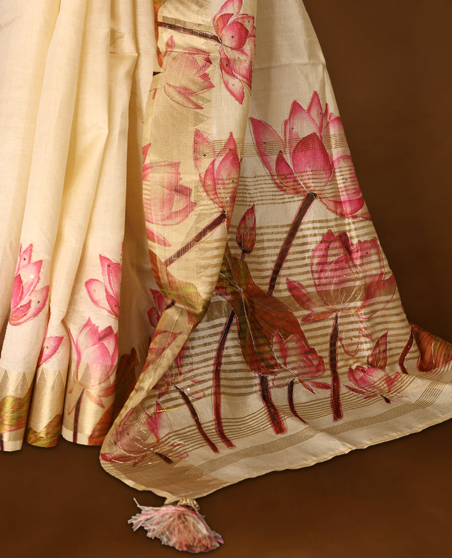 Off white colour Kerala saree crafted in soft tussar, adorned with vibrant pink lotus floral prints with thread and sequence work on the body and pallu, enhanced by a subtle golden zari border, Paired with a matching blouse.