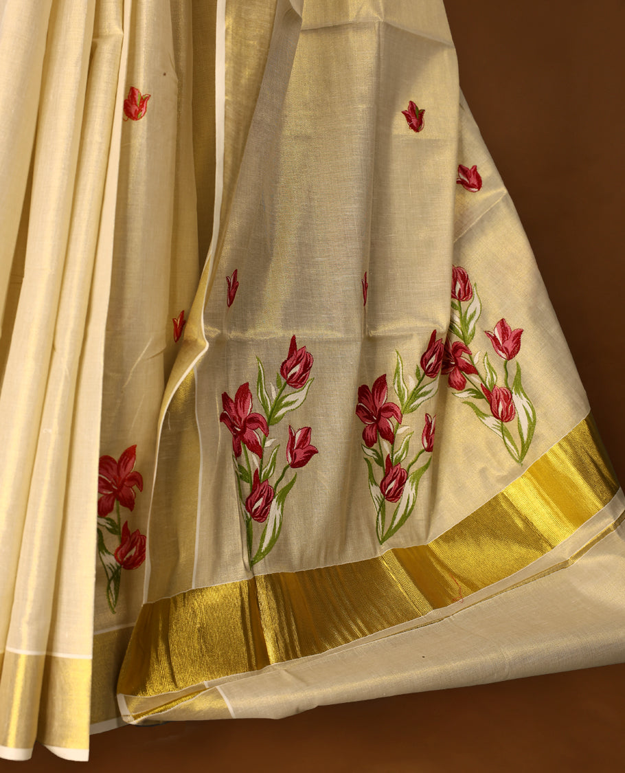 Light Gold colour Tissue Kerala saree featuring Flower Embroidery body and a beautifully woven Gold Kasavu border with Red & Pink colour Floral embroidery work, paired with a matching blouse perfect for festive occasions.