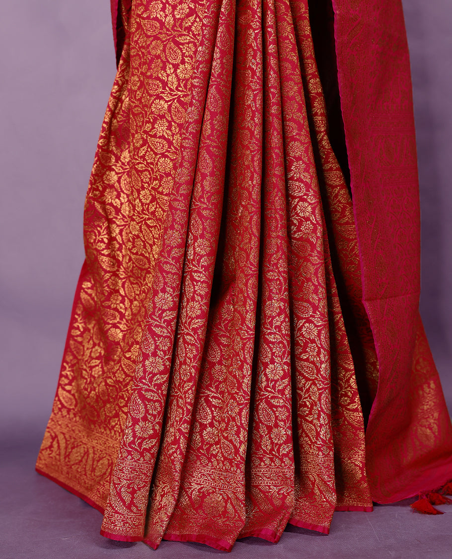 Rani pink colour semi Banaras Katan silk saree featuring intricate Antique Bronze zari floral and vine patterns woven throughout the body, enhanced with a rich traditional border and detailed pallu, paired with a matching blouse piece.