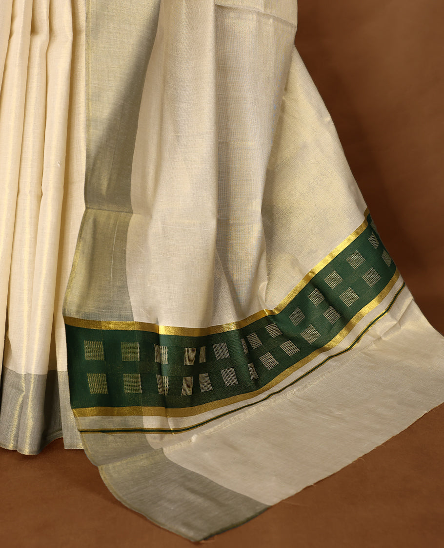 Elegant light gold Colour soft tissue Kerala saree featuring a plain body, muted green zari border, and a striking green woven checkered pallu, paired with a matching blouse.