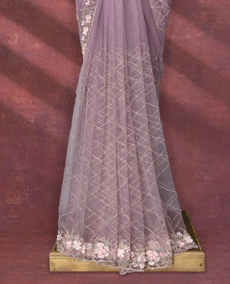 Lavender colour net designer saree featuring crisscross cut beads detailing on the body, adorned with beads and sequin worked floral kodi scallop border, paired with a matching worked blouse