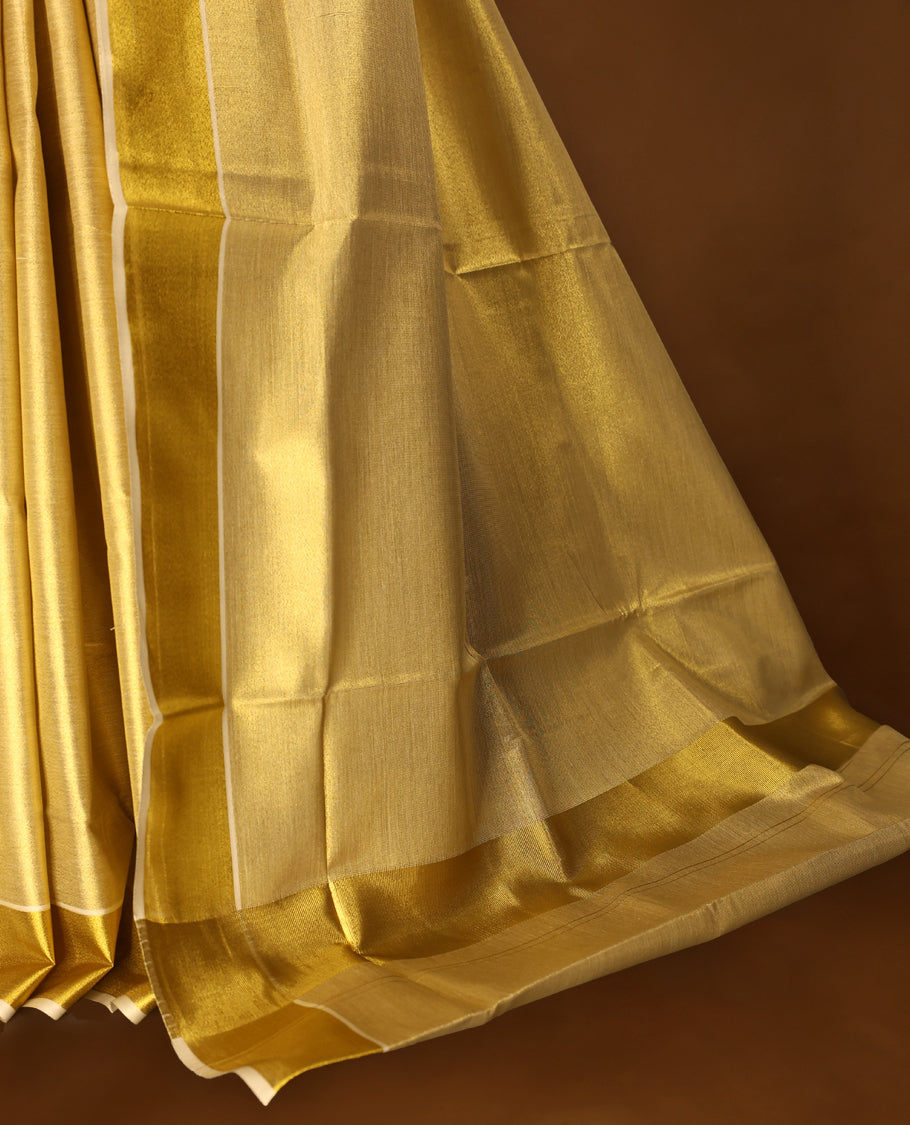 Gold colour Tissue Kerala saree featuring Plain body and a beautifully woven Gold Kasavu border, paired with a matching blouse perfect for festive occasions.