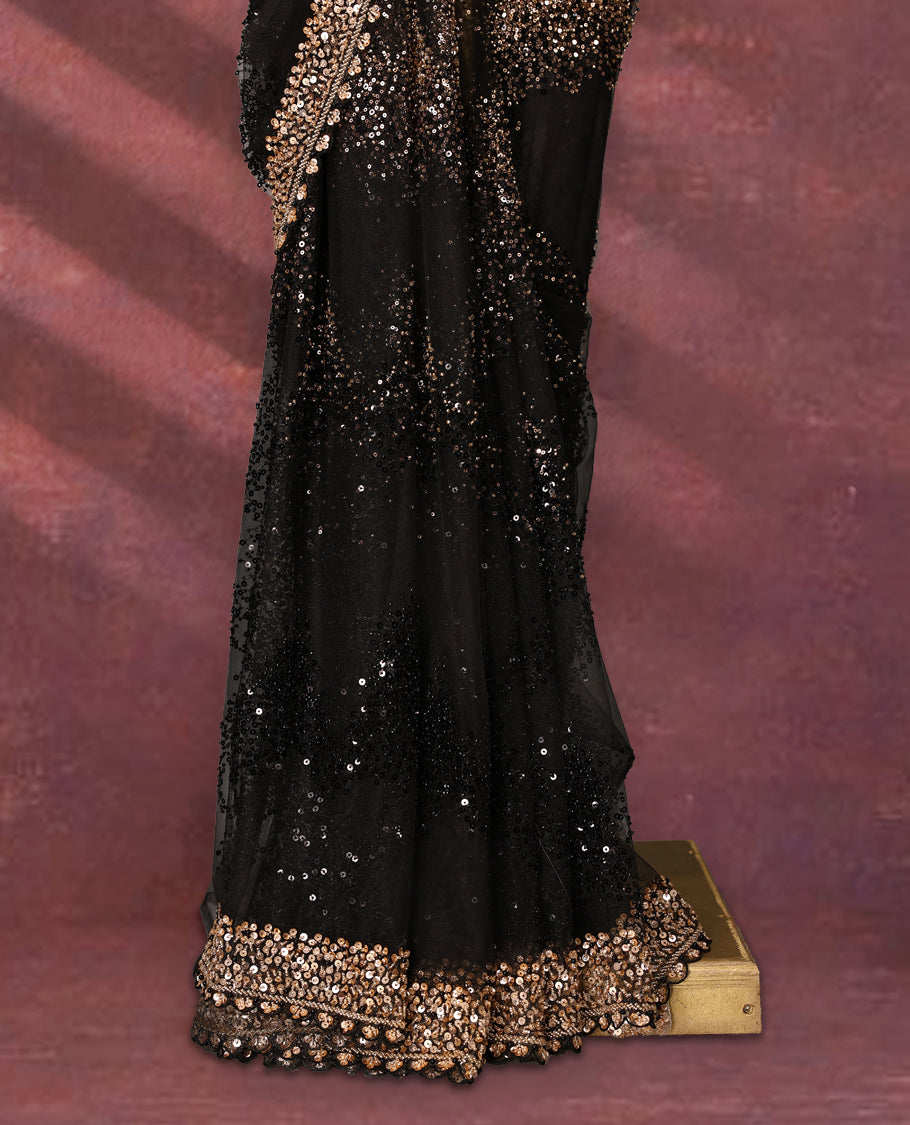 Black colour net designer saree embellished with all over shimmering sequin work in diagonal patterns and a heavily sequined border, exuding glamour and elegance, paired with a matching worked blouse for a striking look
