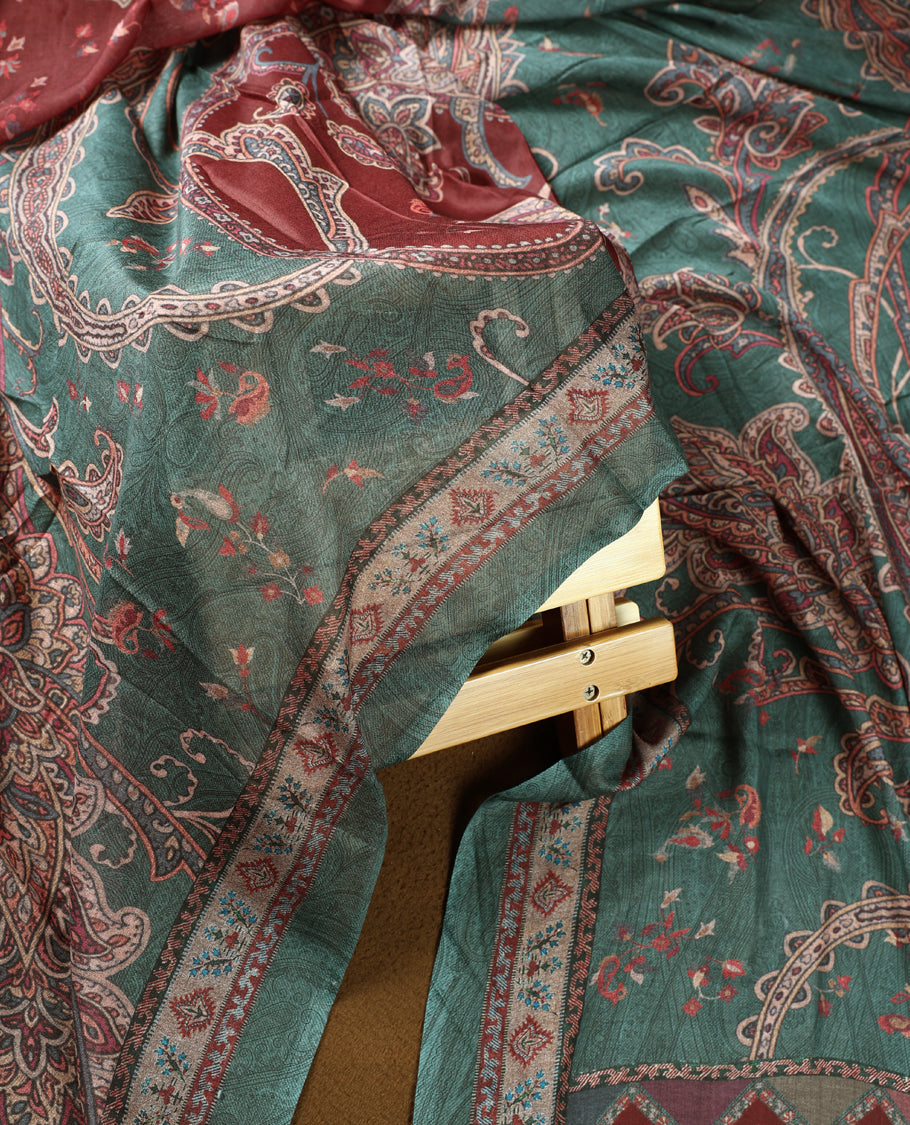 Pine green colour churidhar material featuring intricate paisley prints and delicate embroidery, paired with a plain matching bottom and a printed dupatta.
