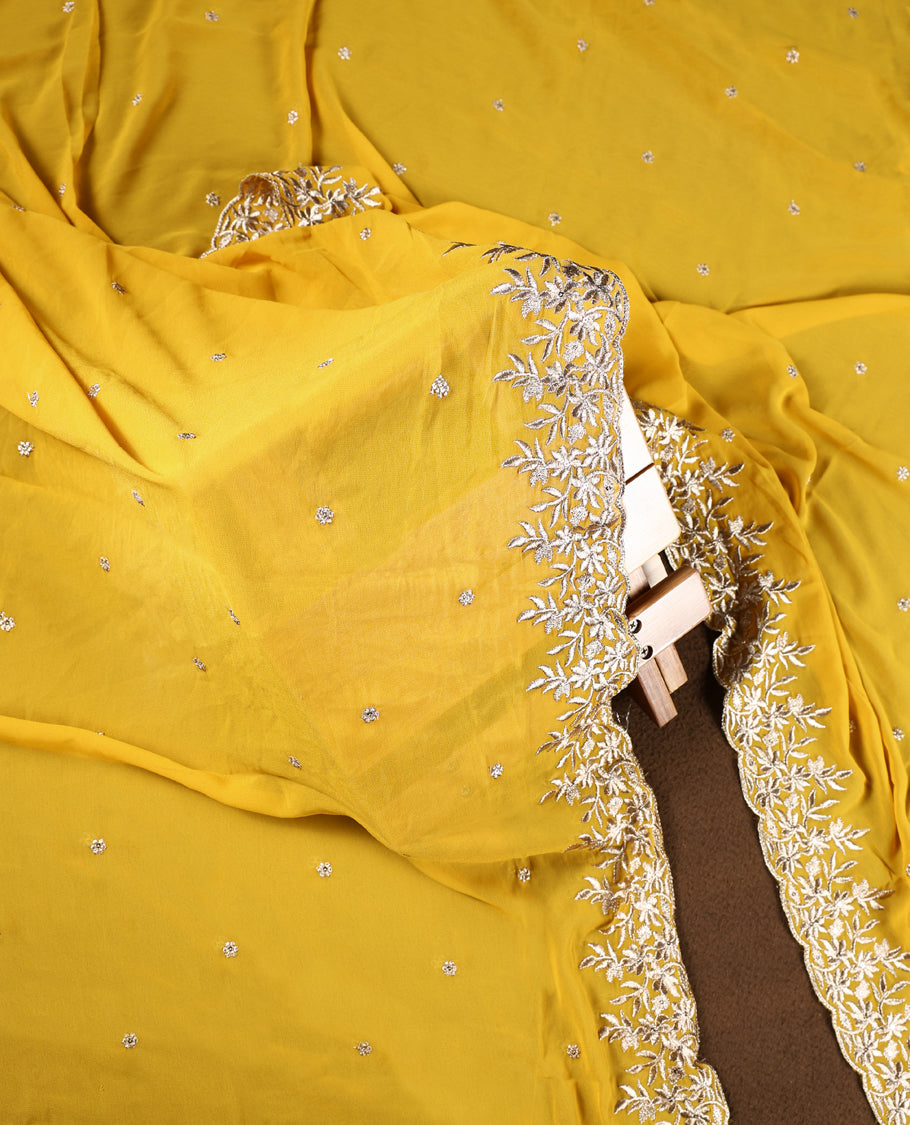Yellow colour churidhar material adorned with elegant golden floral embroidery and delicate motifs, paired with a matching embroidered dupatta and plain bottom.