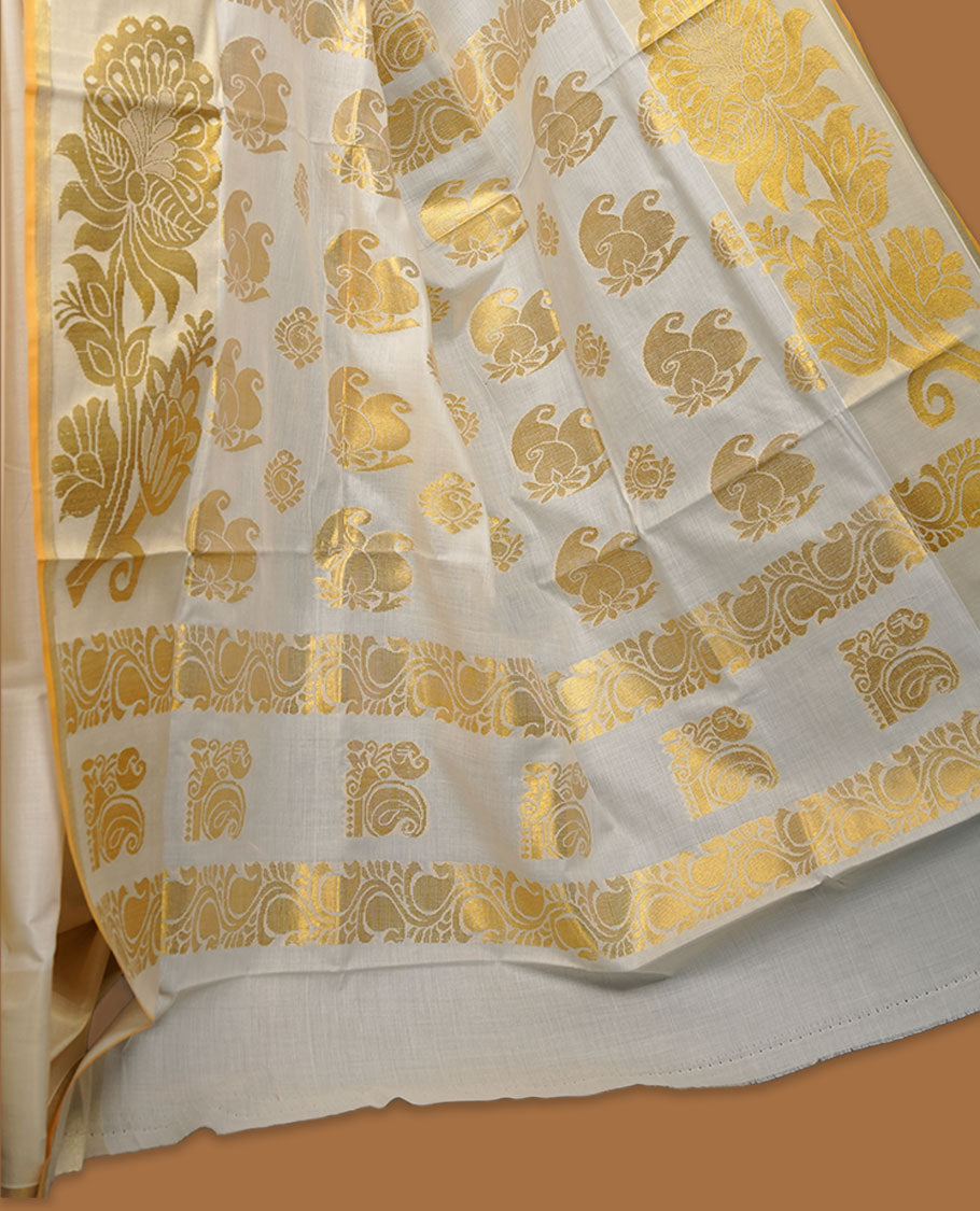 off-white cotton Kerala saree adorned with rich gold zari motifs across the pallu, finished with a classic kasavu border and subtle buttas on the body, paired with a matching blouse