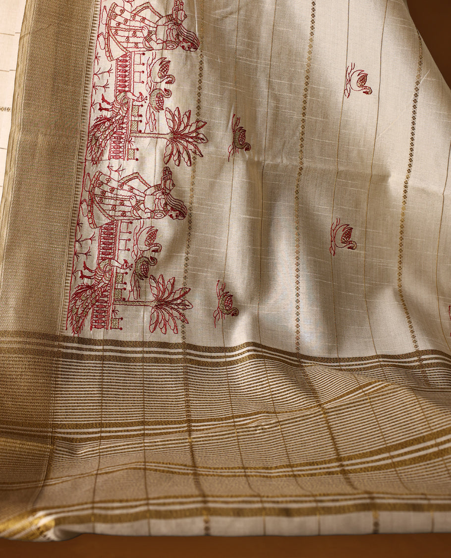 Cream colour Soft Tussar saree featuring fine golden woven stripes across the body, accentuated with maroon village and temple motifs on the pallu, finished with a rich golden zari border, paired with a matching blouse.