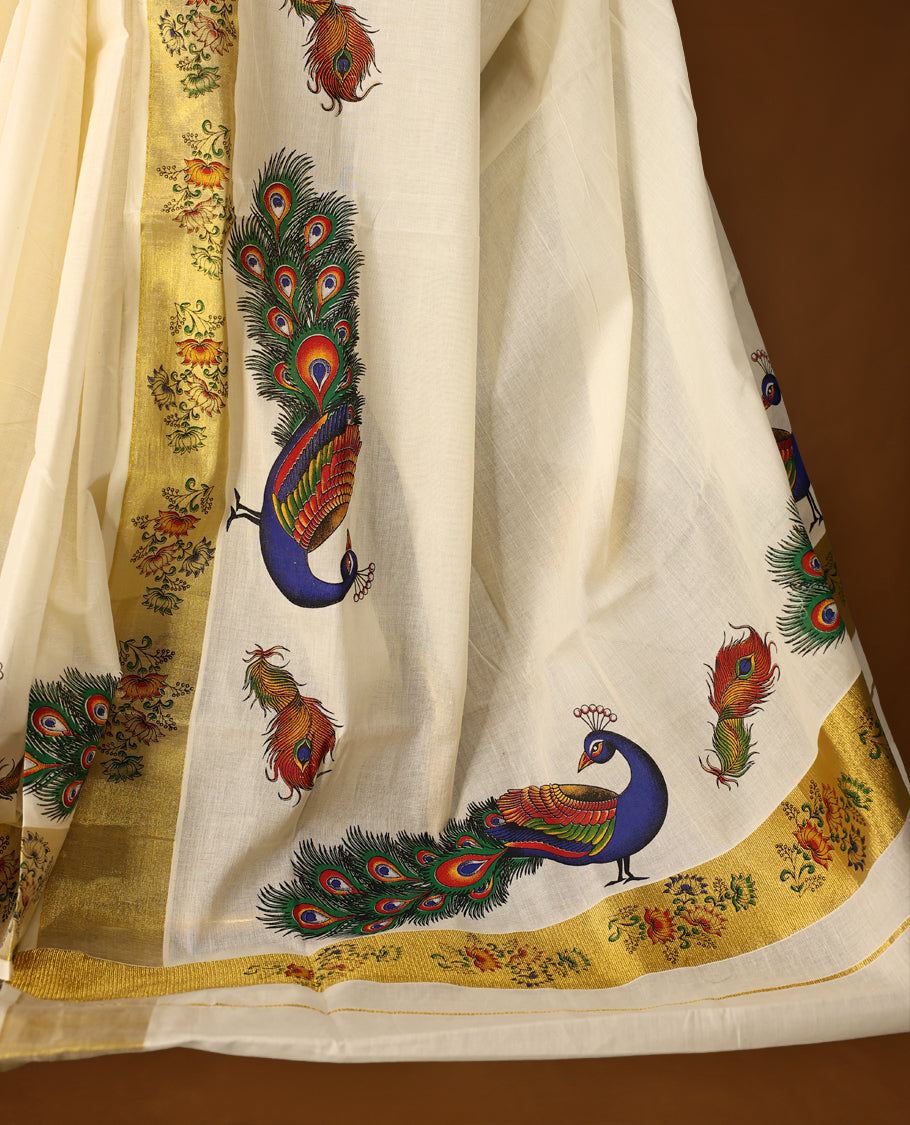 Elegant off white colour cotton Kerala saree with vibrant hand-painted peacock and feather motifs, accented by a floral printed golden border and pallu, paired with a matching blouse for a festive, graceful appeal.