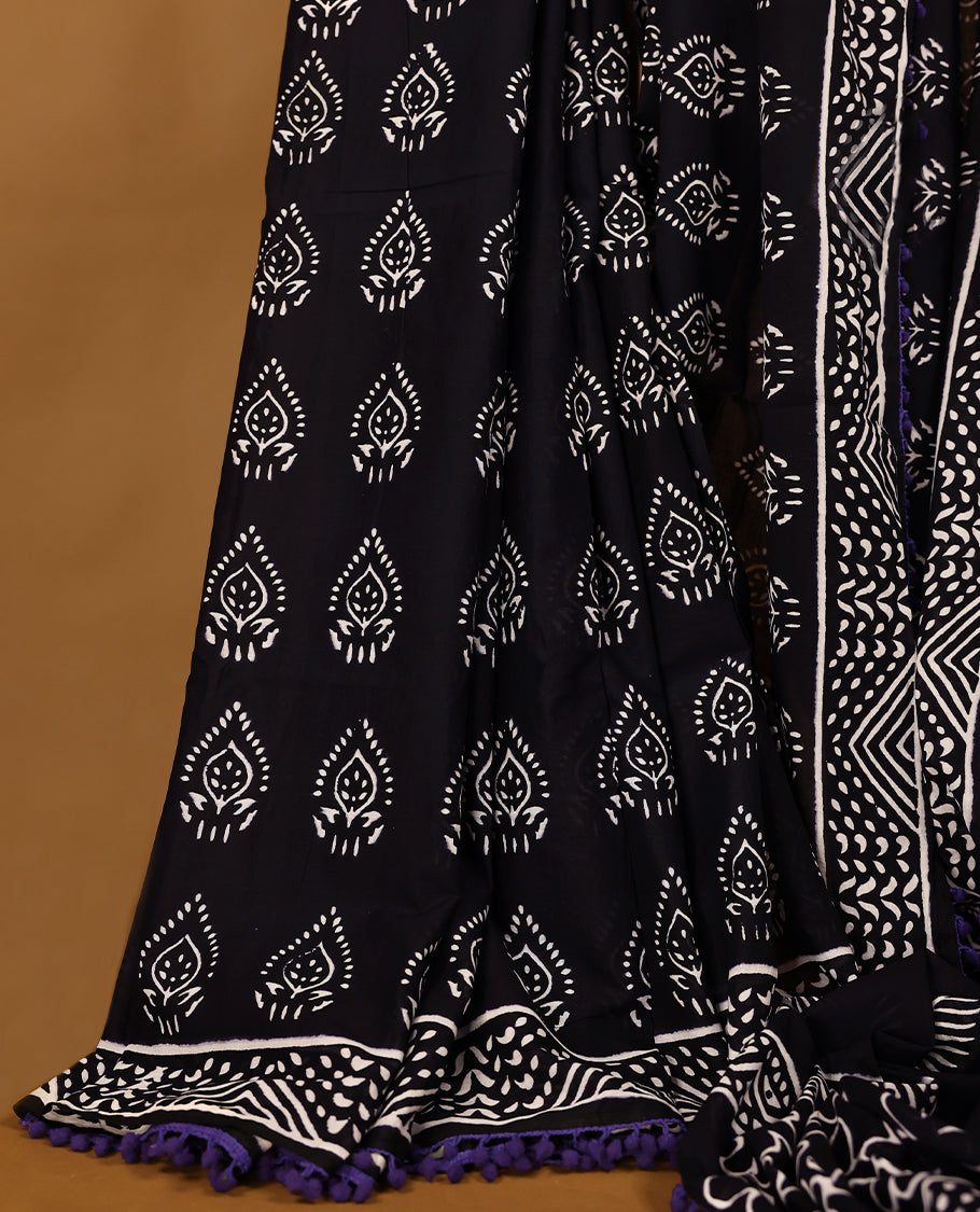 Black cotton saree features intricate white handblock prints, a beautifully detailed border with Violet piping and Self Coloured Blouse