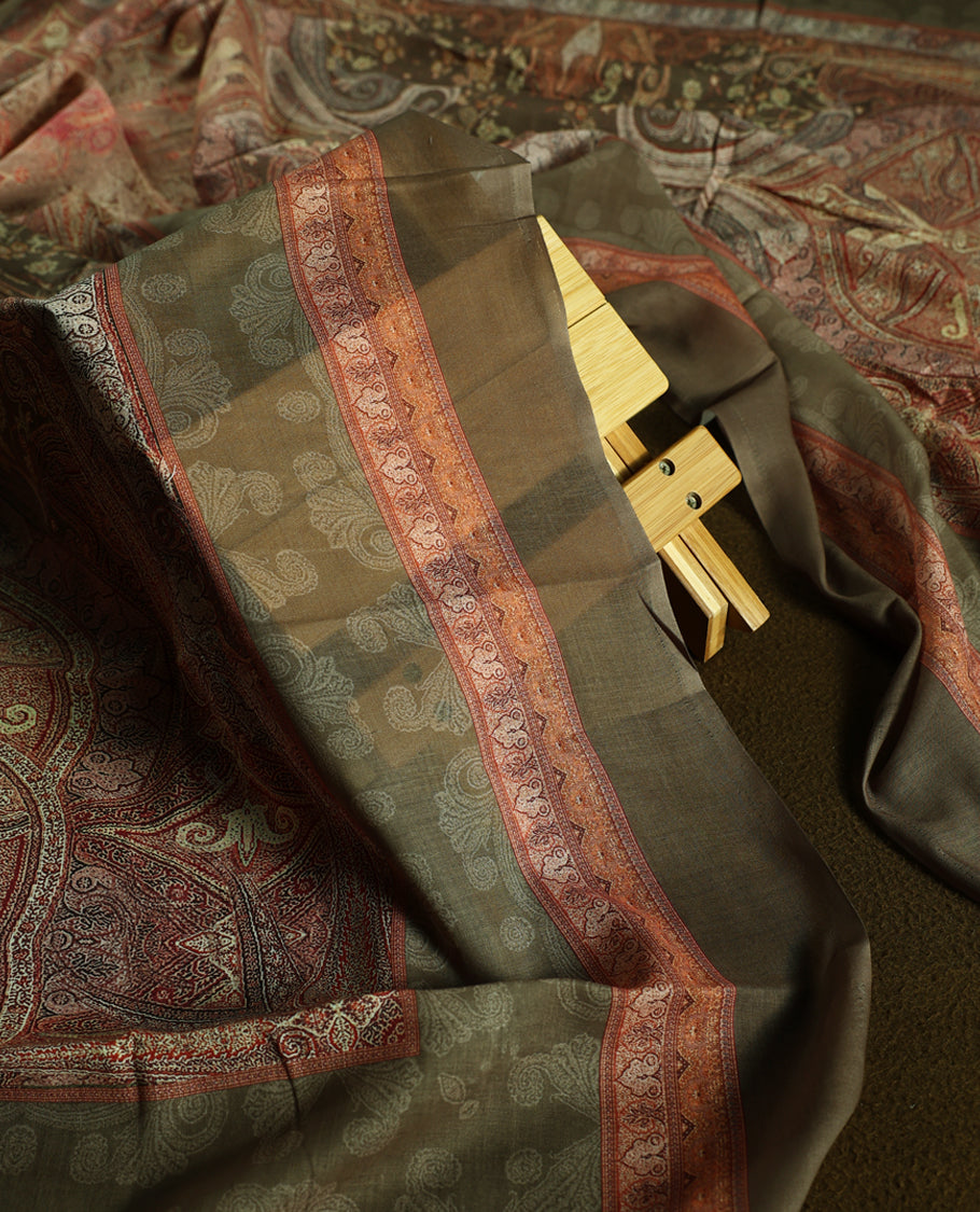 Earthy olive green colour churidhar material featuring intricate embroidery with subtle paisley patterns, paired with a richly printed dupatta and plain bottom.