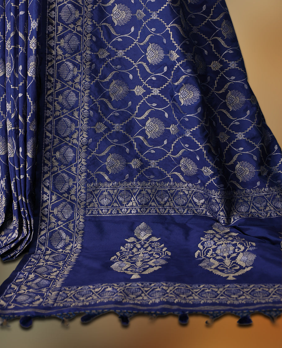 Blue Banaras soft silk saree with silver zari floral vines on the body, intricately woven border, and a grand pallu with bold paisley motifs, Comes with a matching blouse & perfect for elegant occasions.