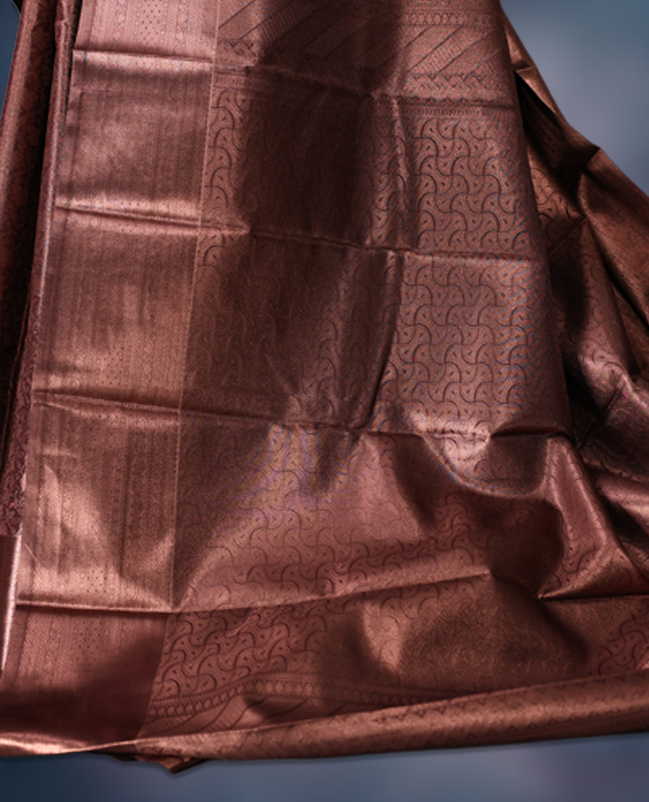 Copper brown semi silk brocade saree adorned with subtle self brocade patterns and a sleek matching woven border and pallu, Comes with a coordinated blouse, perfect for understated traditional elegance.