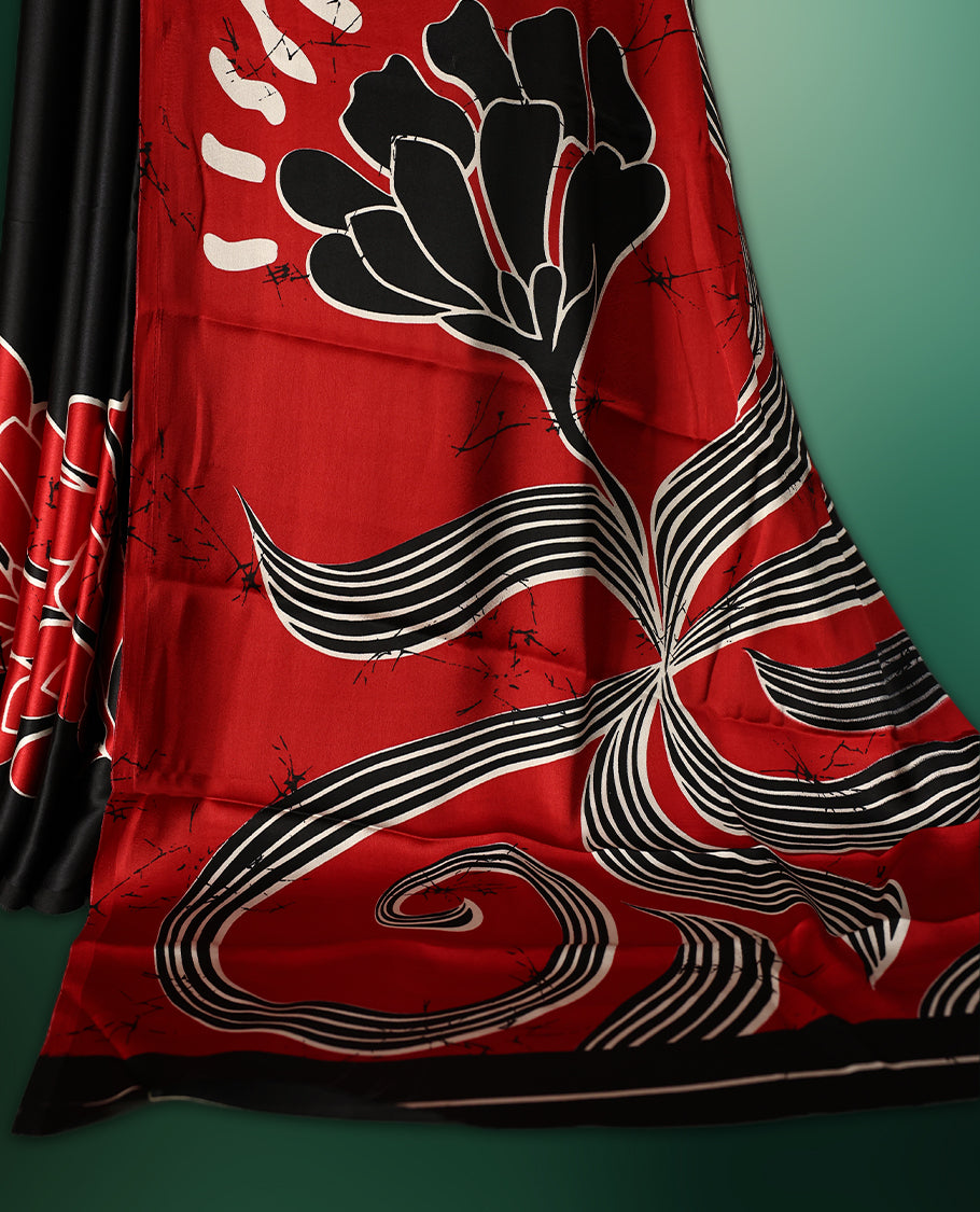 Red and black colour semi modal saree featuring bold abstract floral and swirl patterns, highlighted with contemporary design elements, and paired with a coordinated blouse
