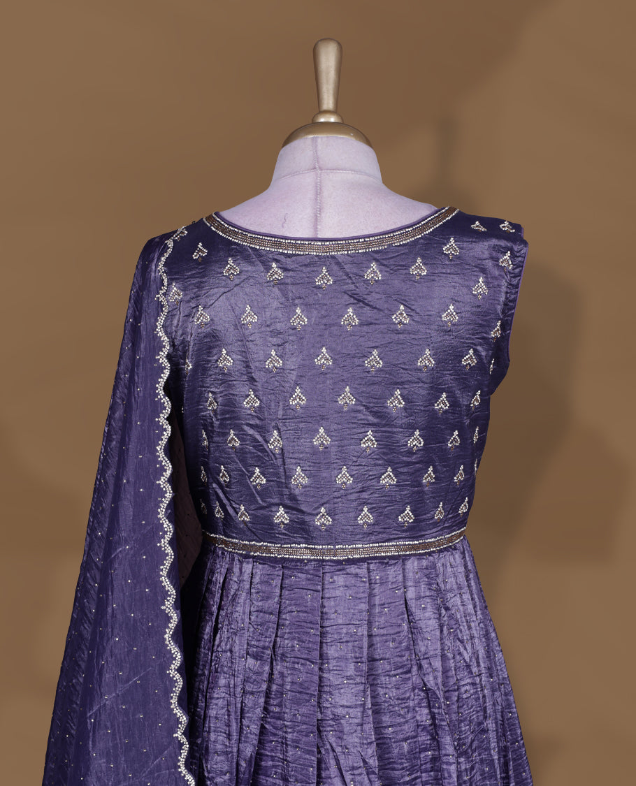 Dark purple colour stitched gown set with sleeveless embroidered yoke, flared ankle‑length silhouette, and attached dupatta featuring dainty butti work and scalloped beaded edging.