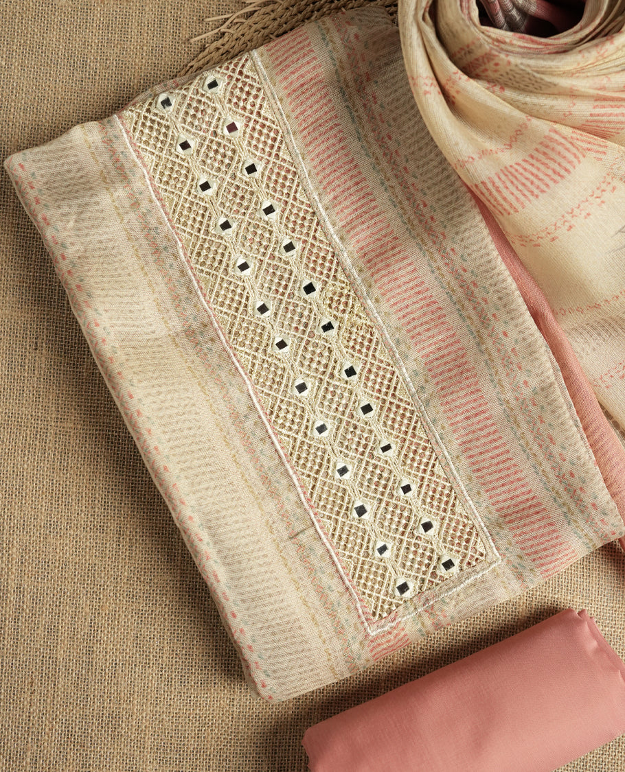 Pastel peach and beige colour suit material with delicate woven mirror work patterns and subtle zari detailing & Includes a soft dupatta with a floral touch and plain matching bottom.