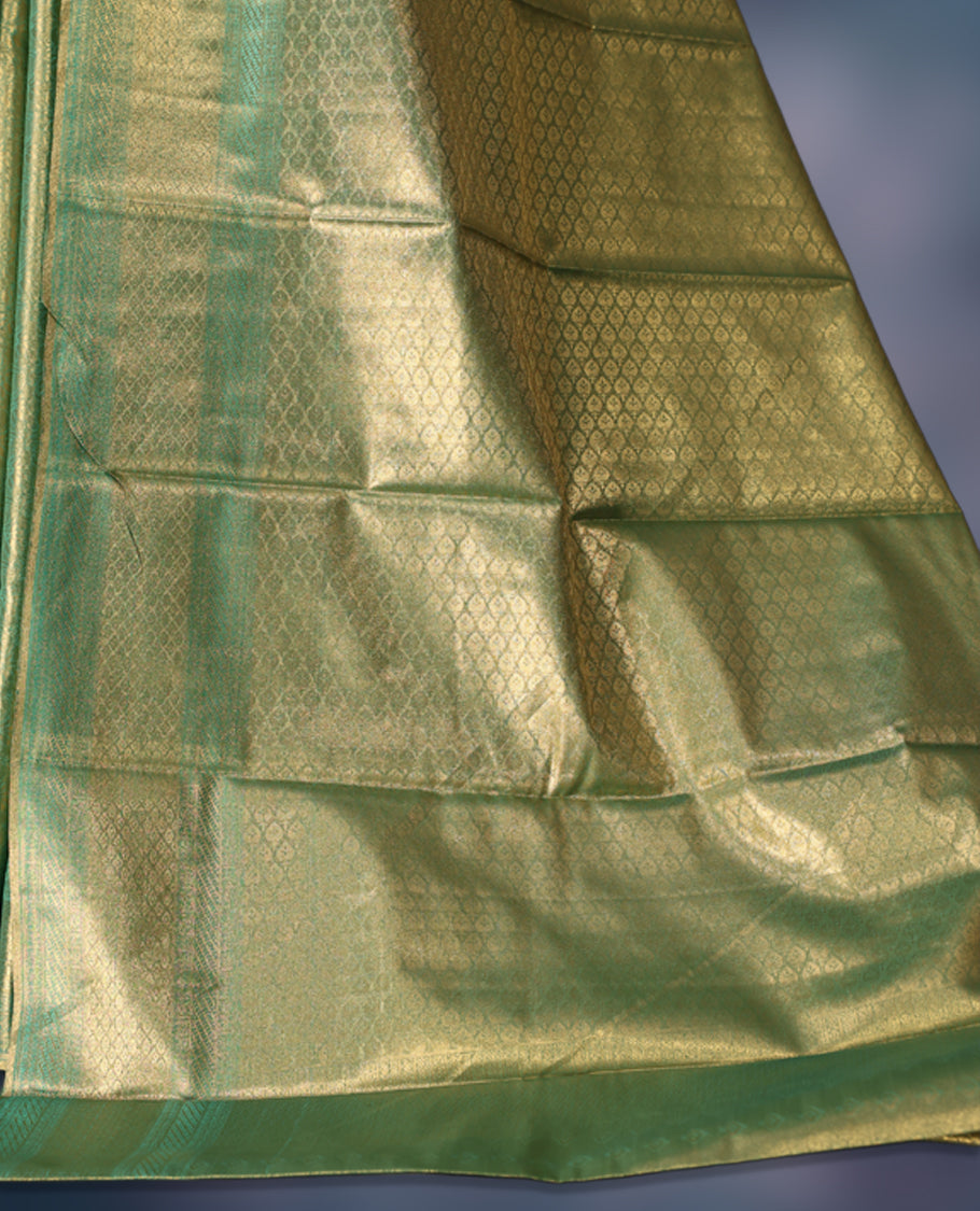 Green semi silk brocade saree featuring delicate self brocade motifs across the body, enhanced with a soft gold toned woven border and pallu, Includes a matching blouse for a graceful ethnic look.