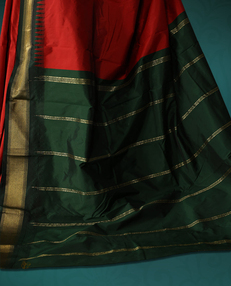 Vibrant Red semi silk saree with plain body, vibrant deep bottle green pallu and matching green border adorned with golden zari, accented with temple motifs along the edges, Paired with a matching blouse, perfect for festive occasions.