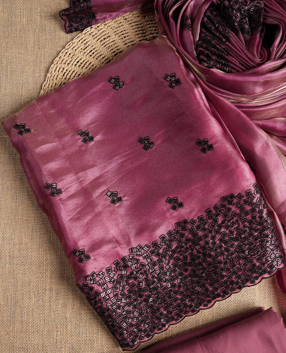 Charming mauve colour dual shaded suit material featuring intricate black thread and sequin embroidery with a delicate lace border, Paired with a matching embroidered dupatta and plain bottom.