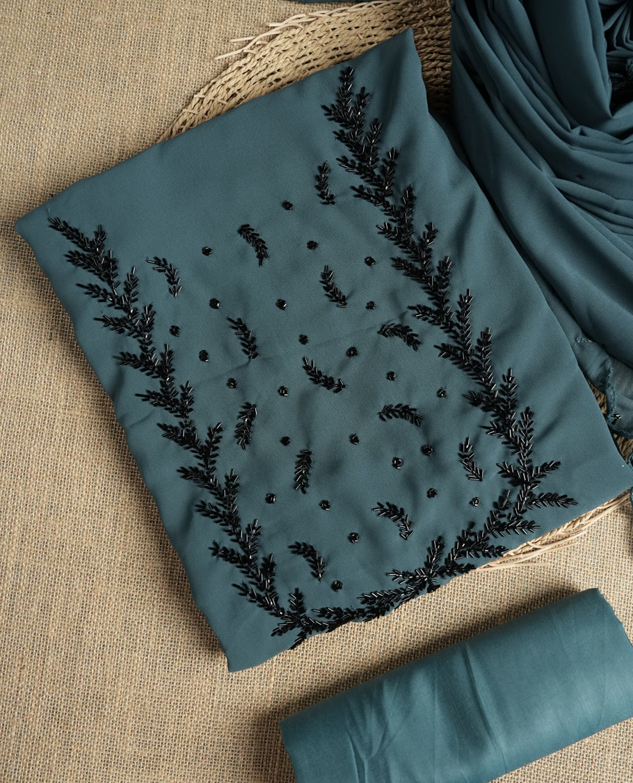Elegant grey colour suit material adorned with intricate black cut beads work, exuding sophisticated charm & paired with a soft dupatta and a matching plain bottom.