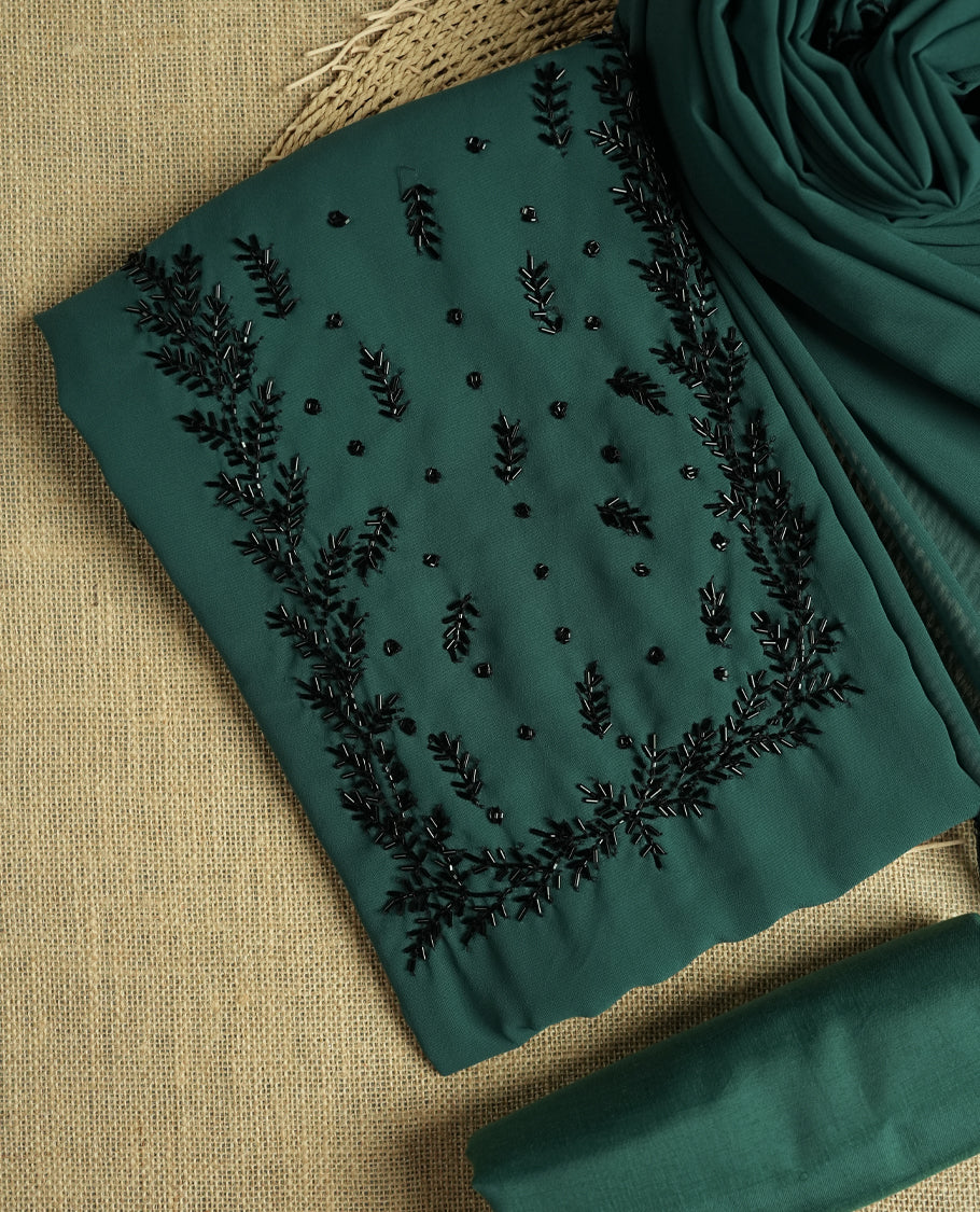 Elegant teal colour suit material adorned with intricate black cut beads work, exuding sophisticated charm & paired with a soft dupatta and a matching plain bottom.
