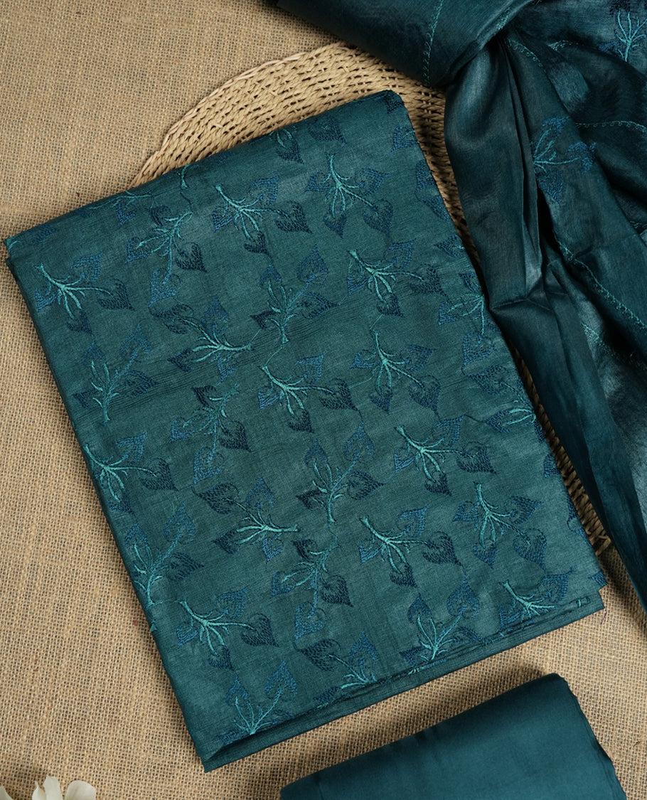 Crystal teal colour tussar suit material featuring elegant floral thread embroidery on the body, paired with a soft dupatta adorned with matching embroidered motifs and tassel edges, along with a plain bottom piece.