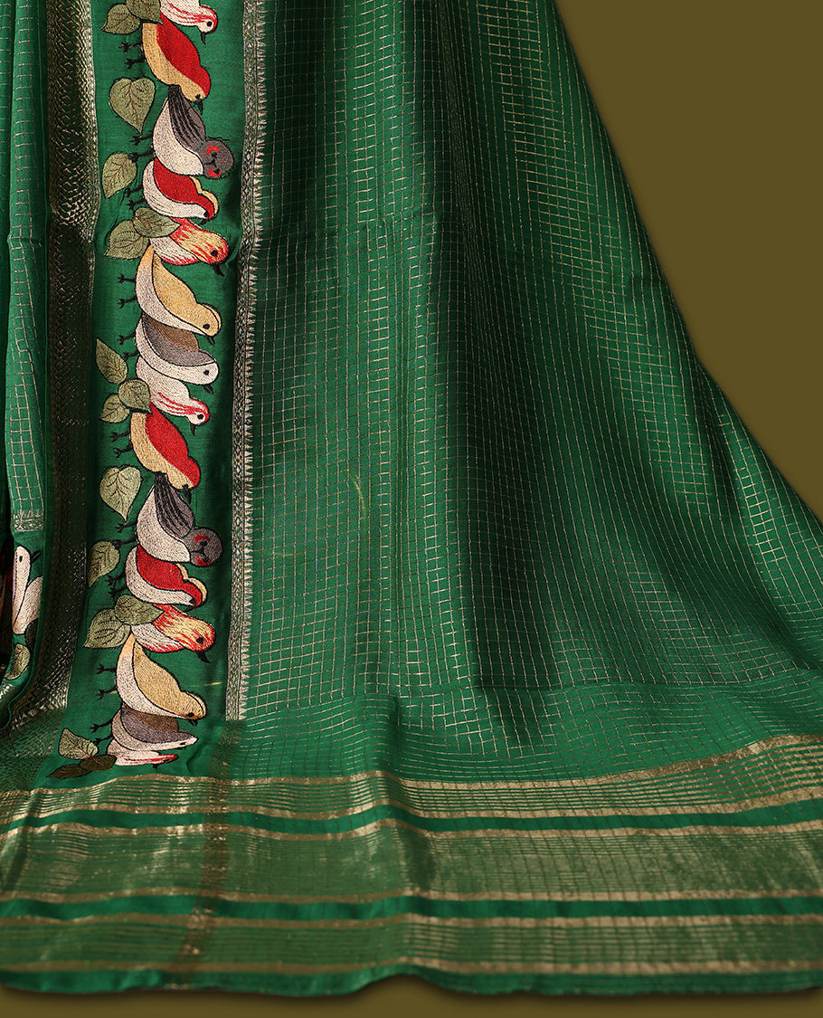 Green viscose saree featuring subtle checkered patterns and a beautifully embroidered bird motif border, paired with a rich pallu & perfect for festive occasions, celebrations, and elegant gatherings.