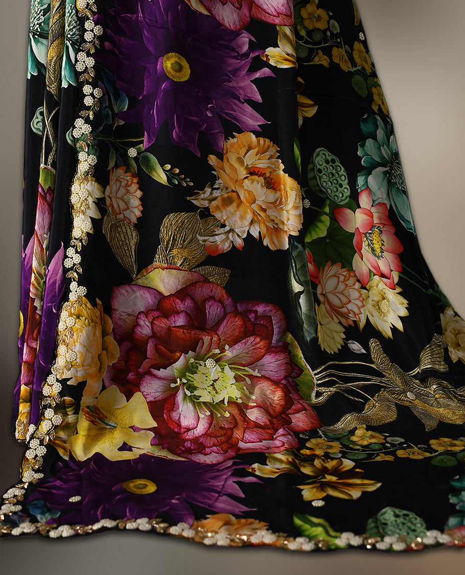 Black pure crepe saree featuring vibrant multi colour floral prints, adorned with delicate cut beads and pearl work along a scalloped border, paired with a matching blouse.