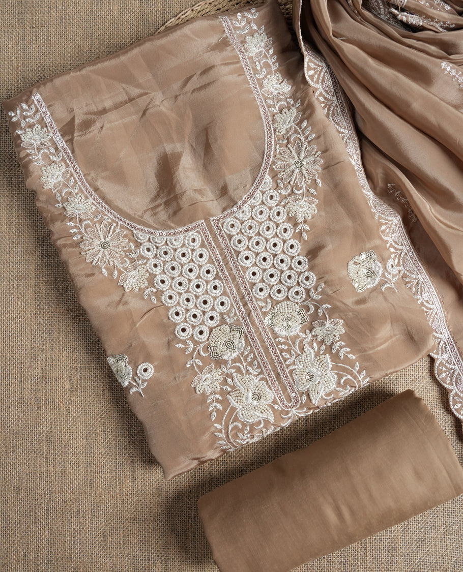 Beige colour suit material adorned with elegant white thread , cut beads & sequin embroidery, highlighted by a delicate lace border & Paired with a matching embroidered dupatta and plain bottom.