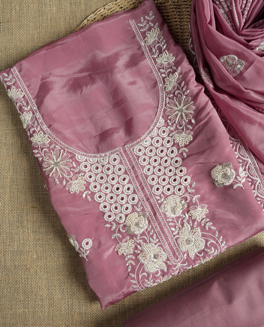 Dusty mauve colour suit material adorned with elegant white thread , cut beads & sequin embroidery, highlighted by a delicate lace border & Paired with a matching embroidered dupatta and plain bottom.