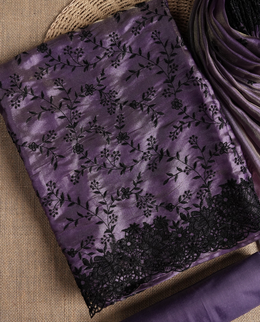Rich lavender colour dual shaded suit material with delicate black floral embroidery and lace border & Includes matching dupatta with embroidered motifs and plain bottom fabric.