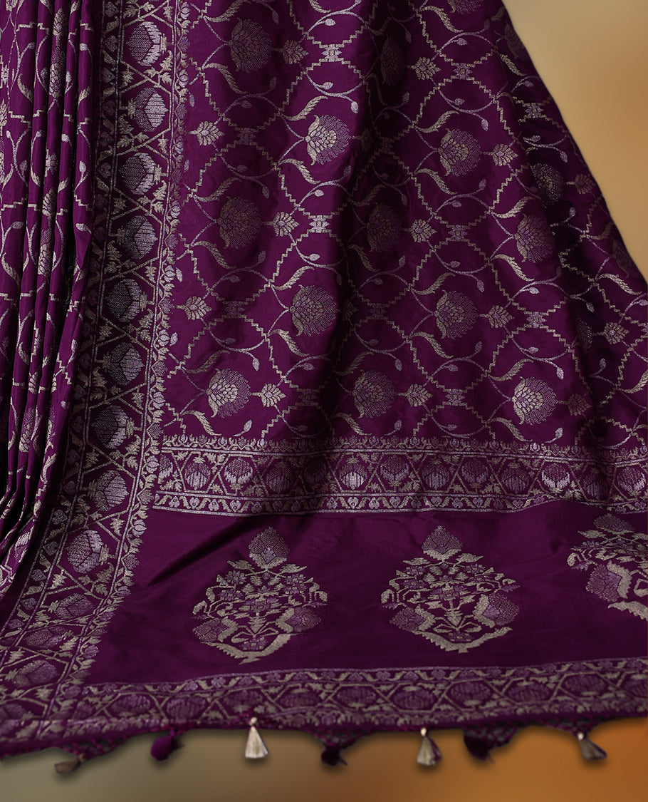 Rich purple Banaras soft silk saree with all over silver zari floral vines, ornate woven border, and bold pallu with paisley motifs. Comes with a matching blouse & Ideal for weddings and festive occasions.