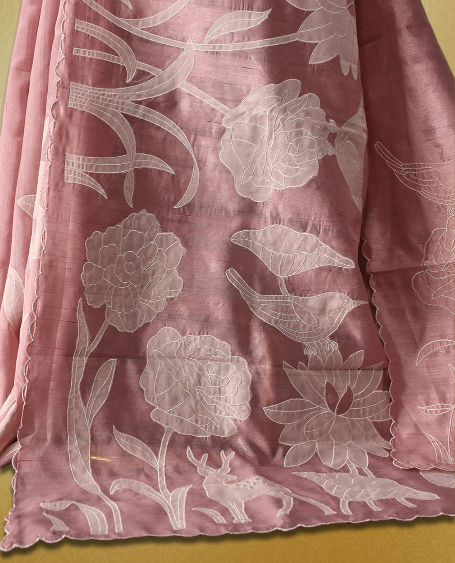 pink colour semi tussar saree featuring elegant white floral and leaf applique work along the body and border, paired with a matching blouse.
