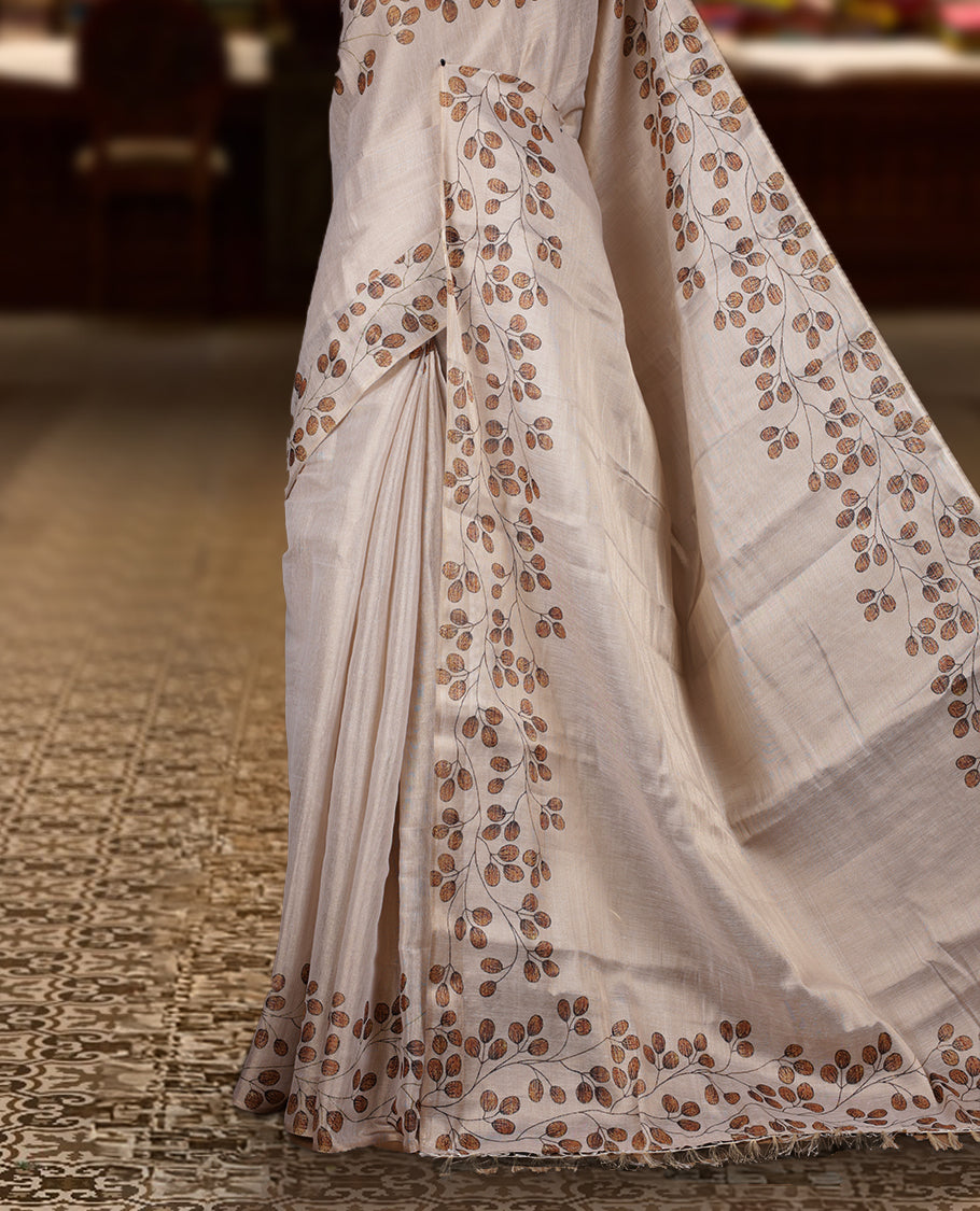 Beige colour Semi tissue saree adorned with earthy toned digital leaf prints on the body and an elegant pallu & comes with a matching blouse piece