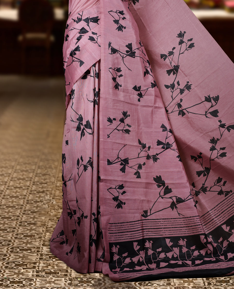 Pastel Pink colour Semi tussar silk saree adorned with black floral prints on the body and an elegant pallu & Comes with a matching blouse piece for a classy look.