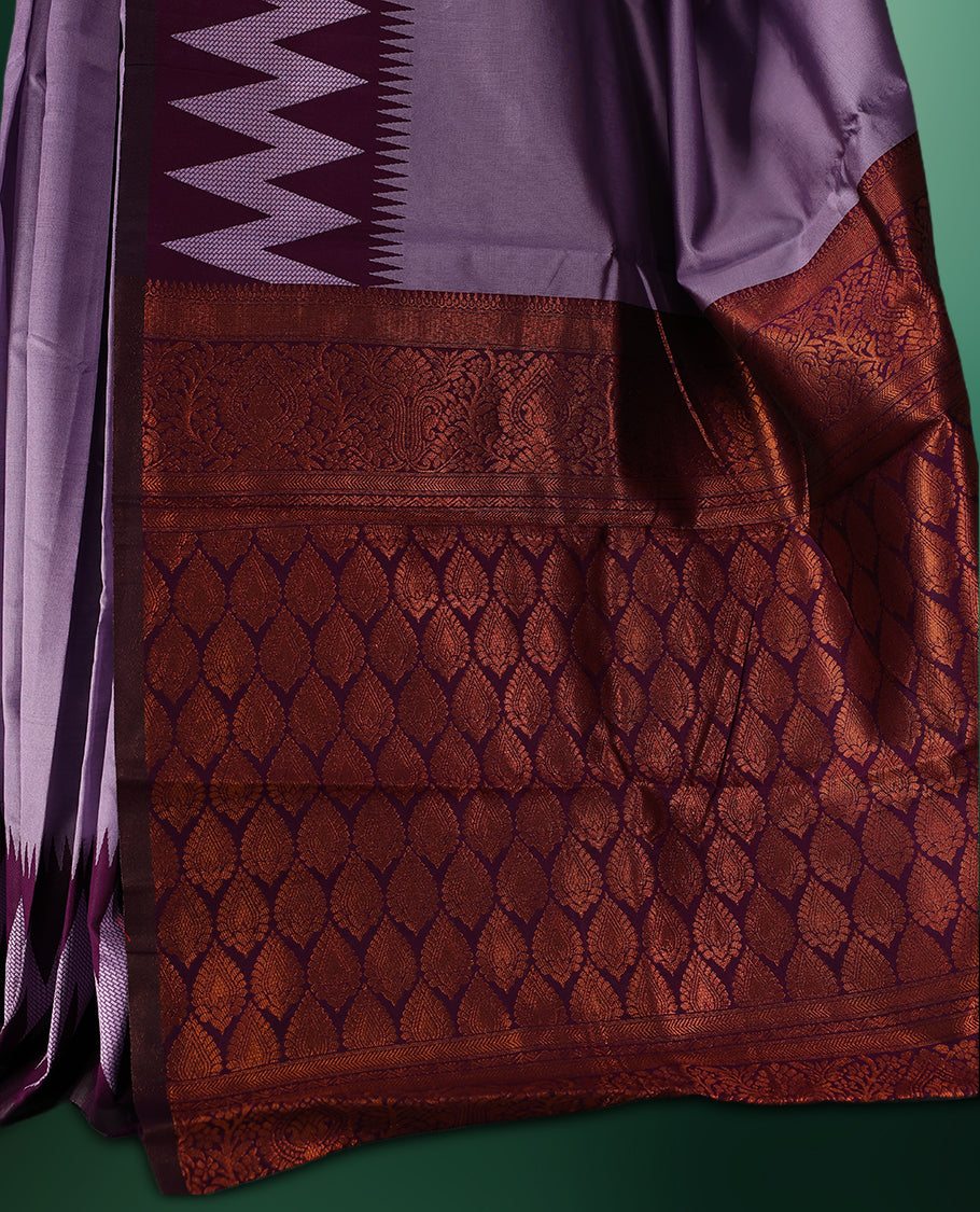 Lavender colour saree accentuated with bold deep purple zigzag woven borders and a contrasting rich copper zari pallu, paired with a matching blouse