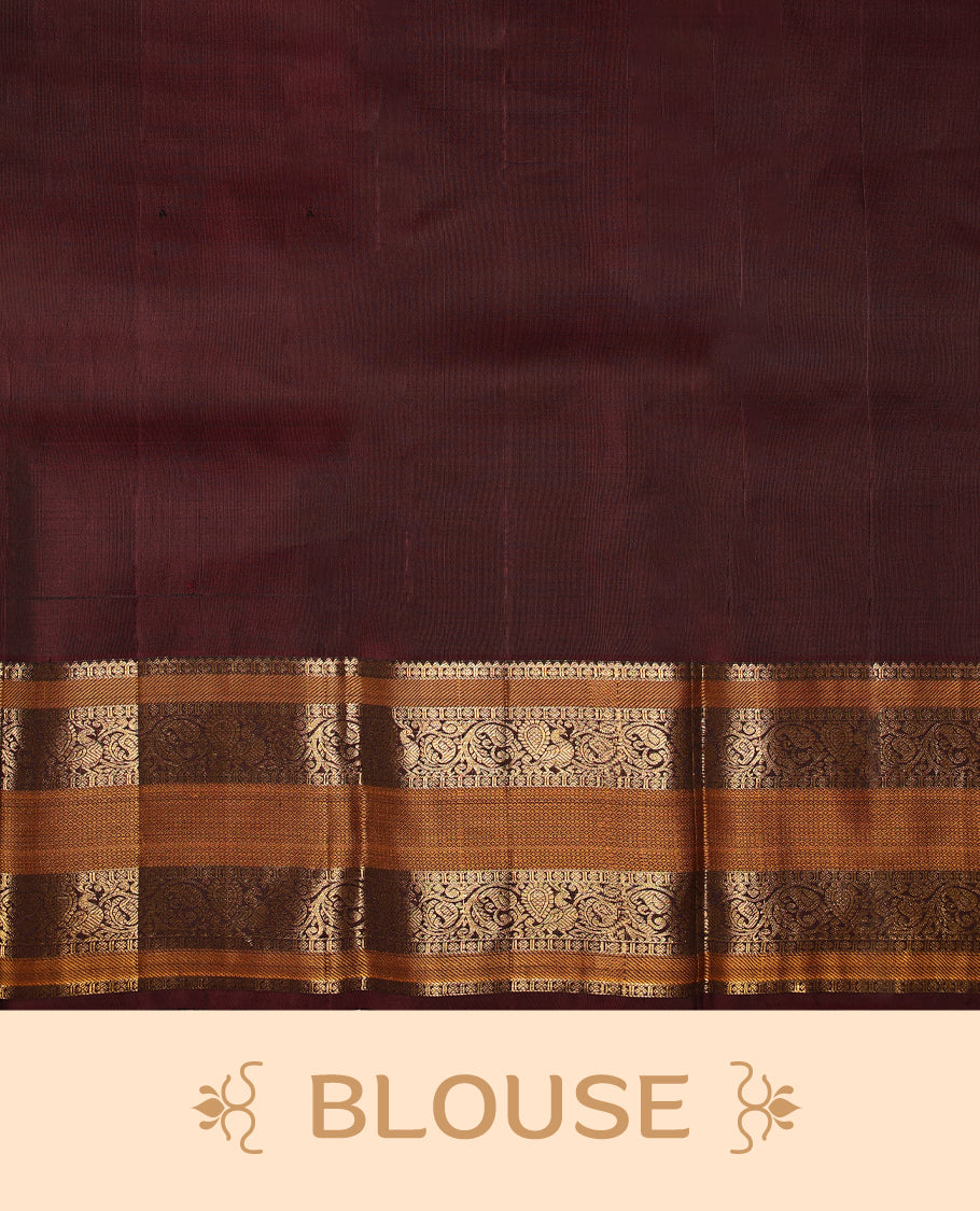 Bottle green pure Kancheepuram saree with gold zari Mayoora Chakra and diamond motifs on the body, contrast brown Kalakshetra border, grand pallu, and matching blouse.
