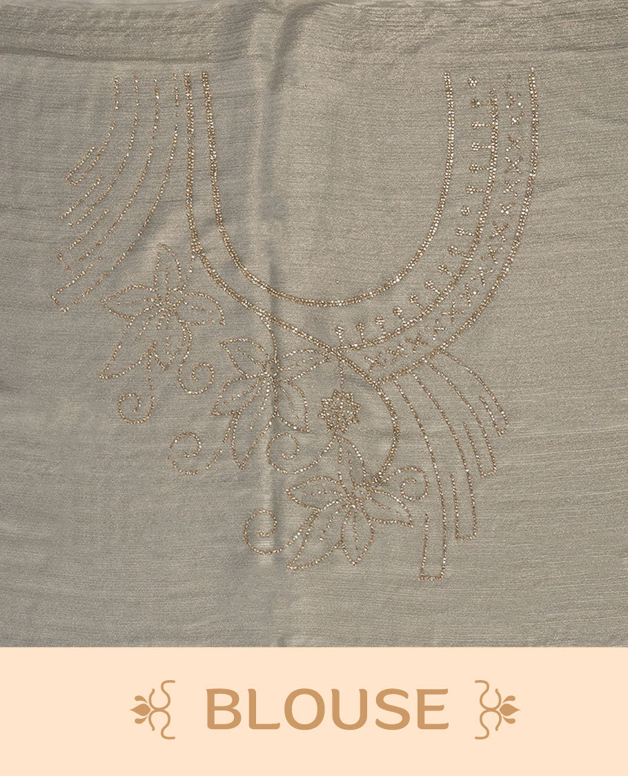 Pastel Cream Colour shimmer fancy saree adorned with scattered gold stone buttas all over the body, paired with a delicate stone worked border and matching blouse