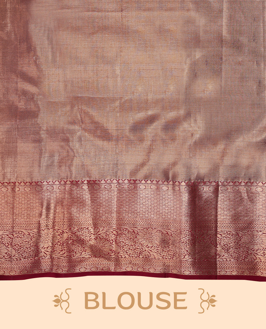 Pastel maroon Colour Kancheepuram tissue silk saree adorned with intricate silver floral zari work on the body, beautifully highlighted by a maroon traditional Rudraksham and floral design border, and paired with a matching blouse.