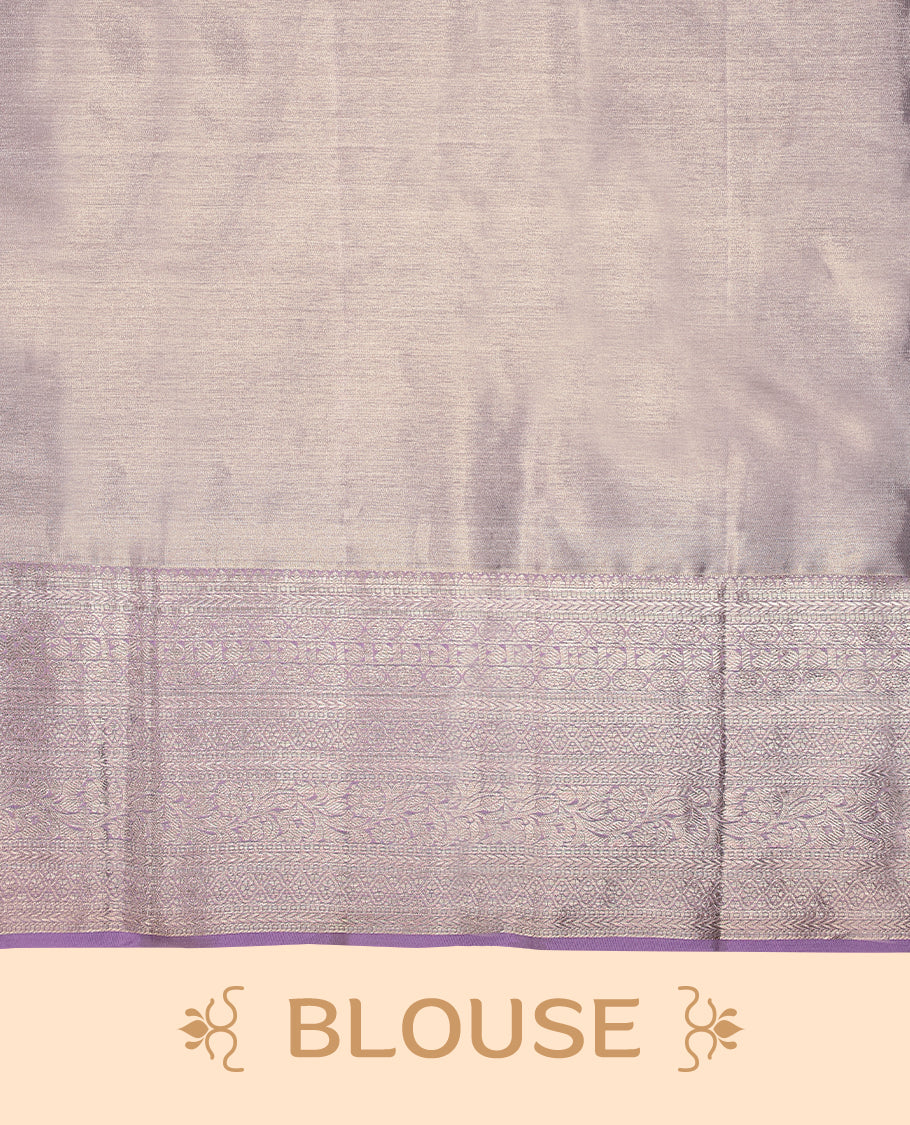 Pastel lavender Colour Kancheepuram tissue silk saree embellished with intricate silver zari work on the body, elegantly enhanced by a lavender traditional Chakkram and floral kodi design border, and paired with a matching blouse.