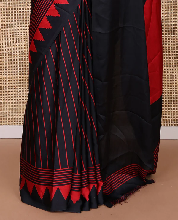 Black sem imodal crepe saree adorned with red vertical line prints, complemented by a temple border and circle butta design on the pallu, paired with a matching printed blouse.