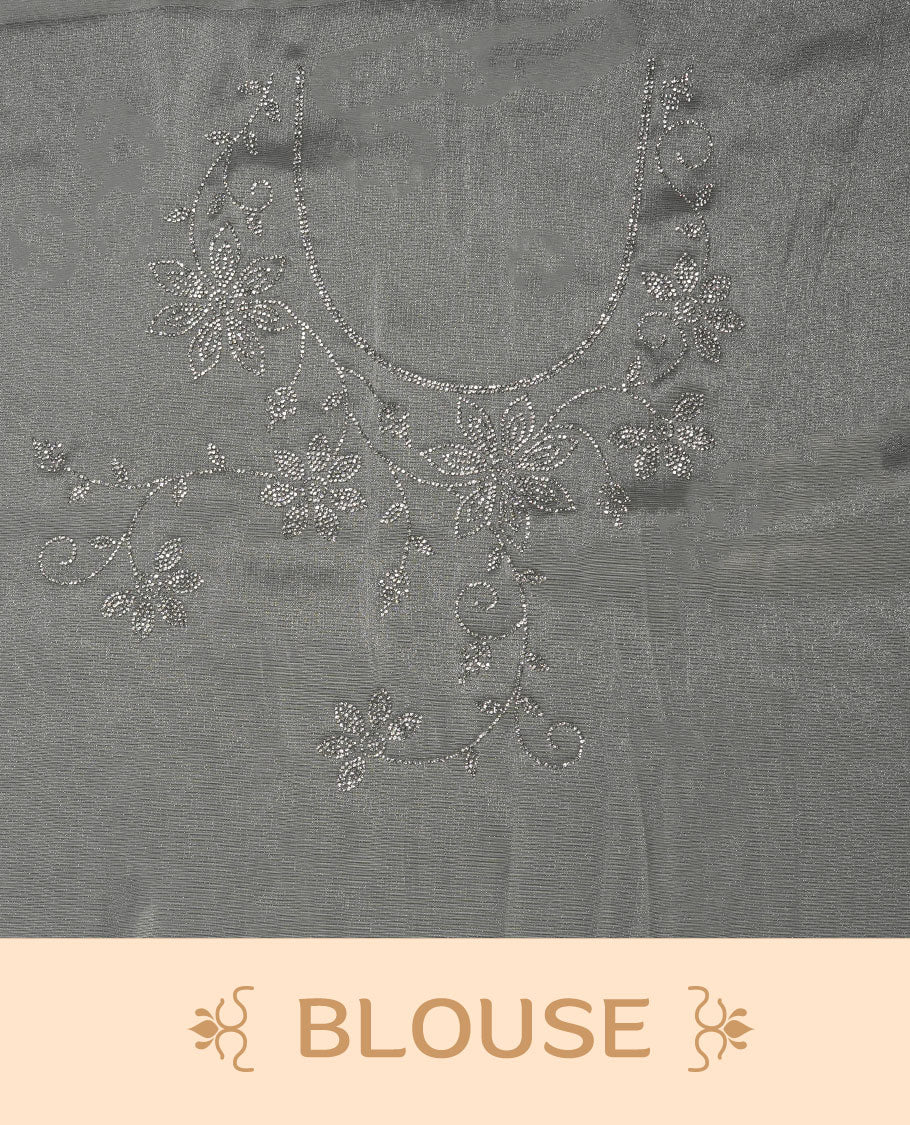 Off white Colour net shimmer fancy saree adorned with scattered white stone buttas all over the body, paired with a delicate stone worked border and matching blouse featuring floral vine stone embroidery