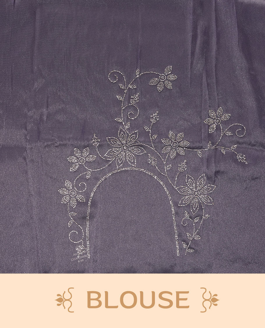 Lavender colour net shimmer fancy saree adorned with scattered white stone buttas all over the body, paired with a delicate stone worked border and matching blouse featuring floral vine stone embroidery