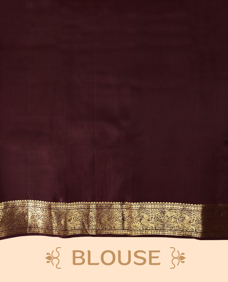 Dark red Colour traditional Kancheepuram silk saree adorned with antique zari check design on the body, featuring a contrasting Traditional border with peacock, deer, and Rudraksham motifs, and paired with a matching blouse.